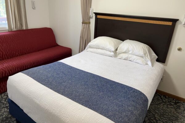 View of streetside bedroom with a queen bed and a sofa sleeper